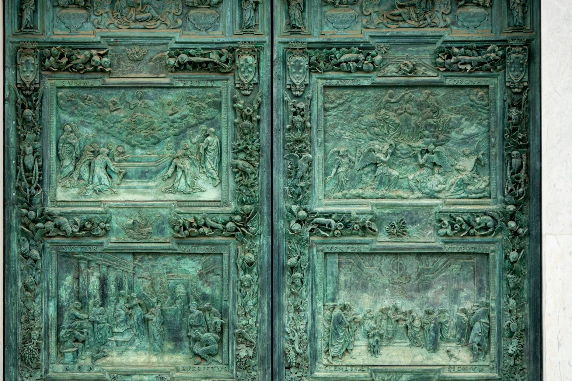 Detaliczne brązowe drzwi katedry z reliefami religijnymi