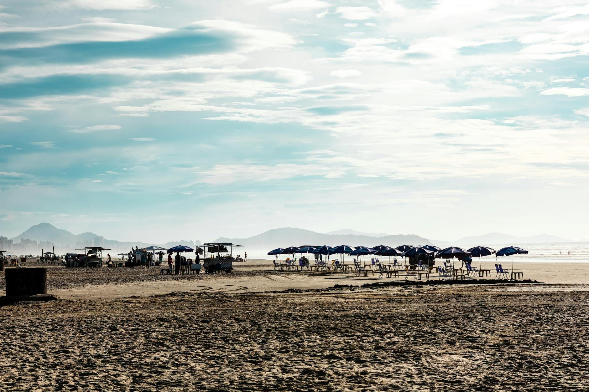 Plaża z kolorowymi parasolami turystycznymi przy bezchmurnym niebie