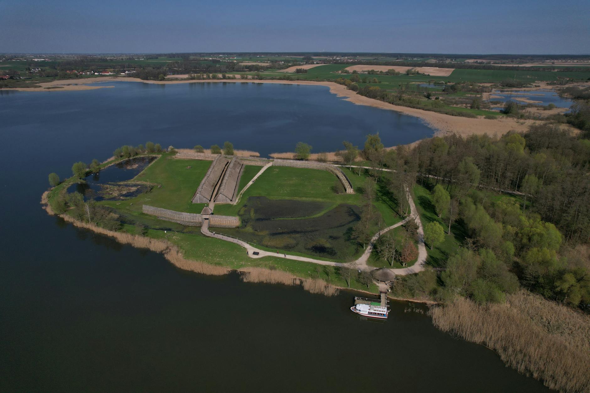 Osada Biskupin nad jeziorem, widok na drewniane zabudowania