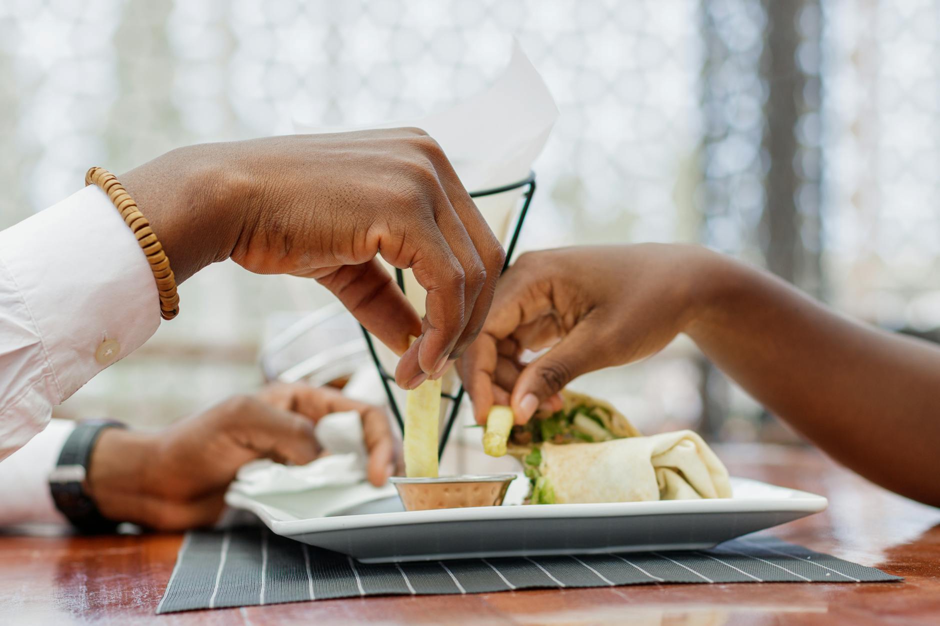 Para dzieląca się jedzeniem przy stoliku w restauracji