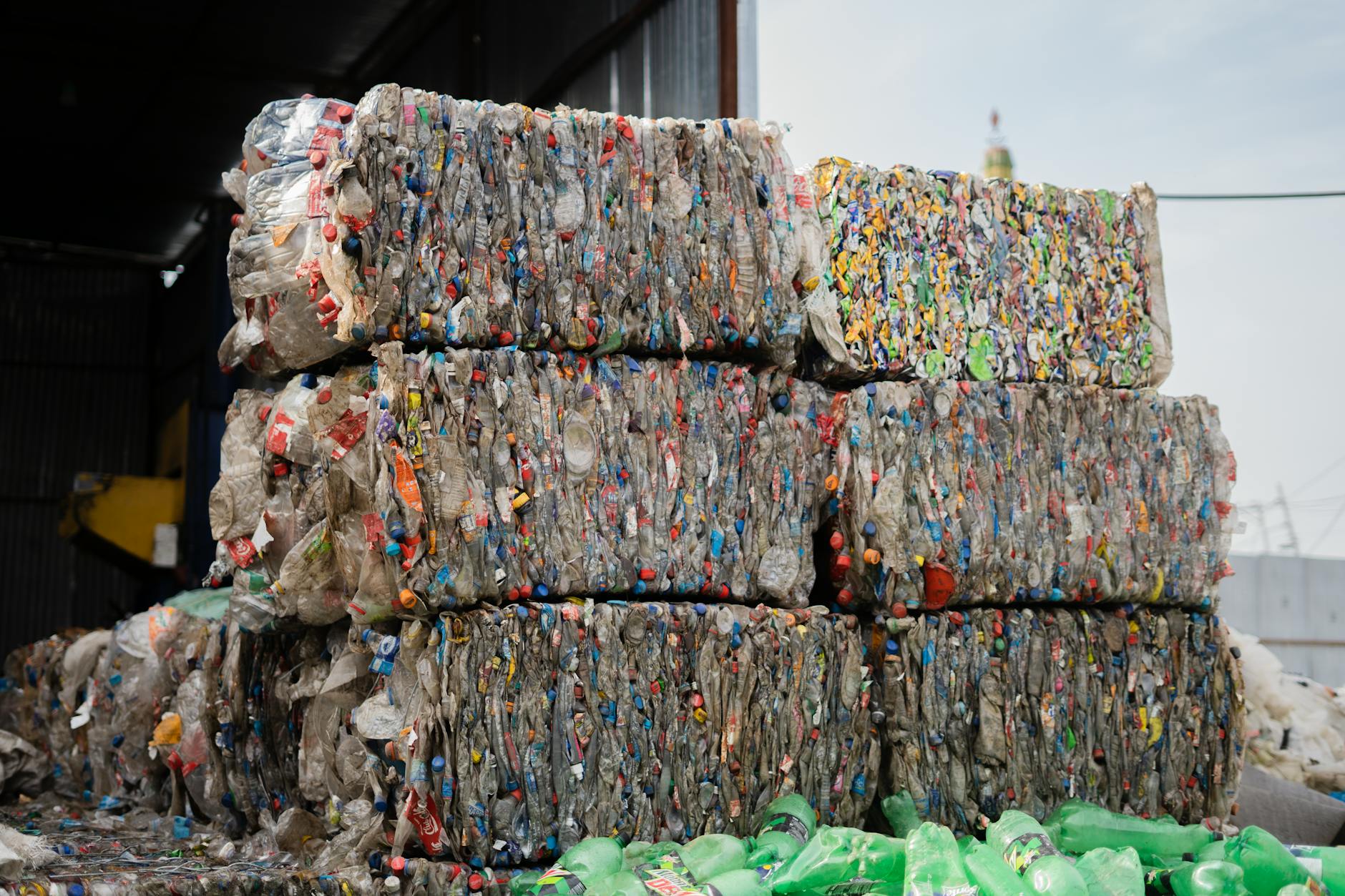 Sprasowane butelki plastikowe ułożone w kostki w zakładzie recyklingu