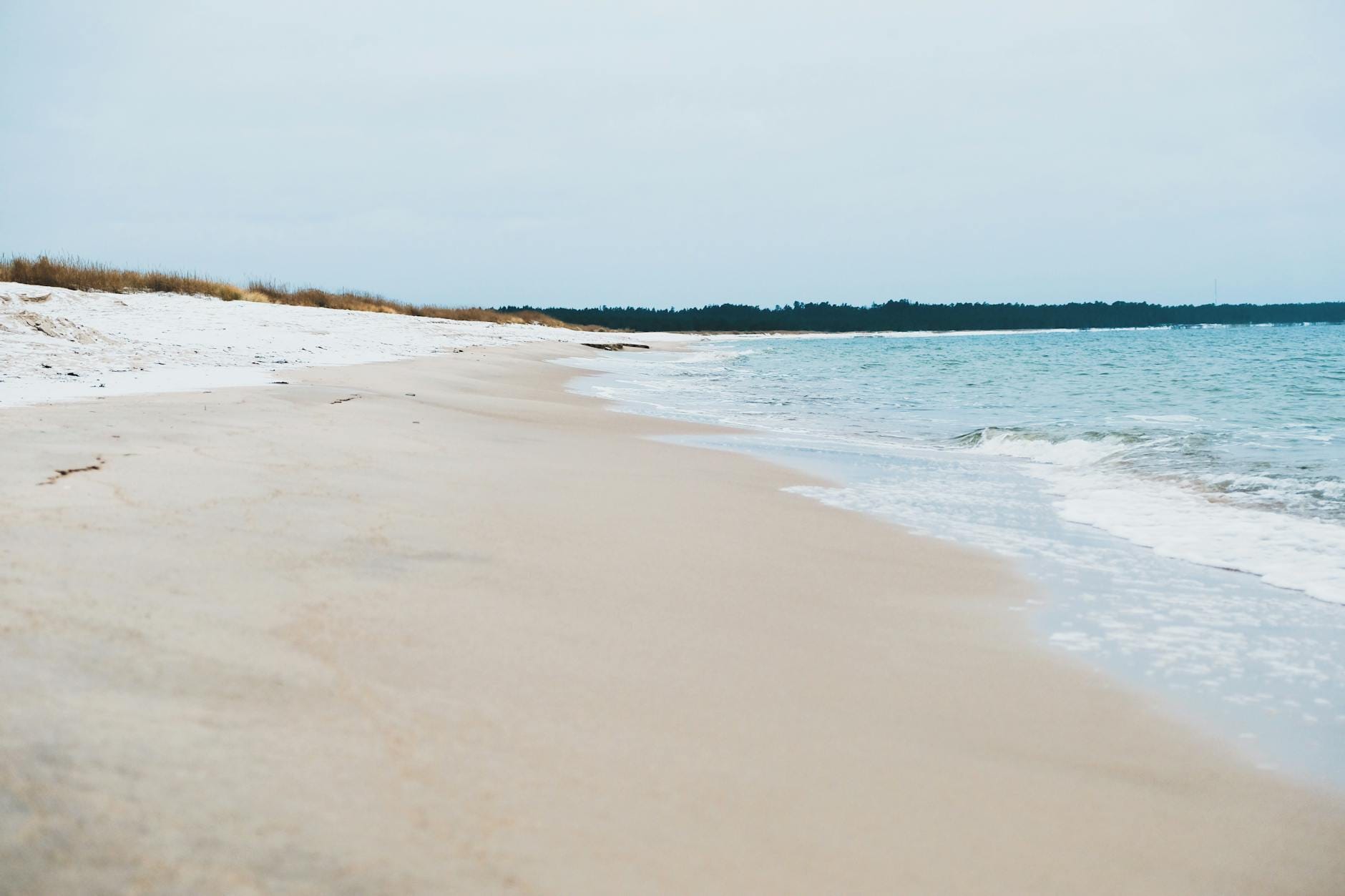 Zimowa, spokojna plaża z miękkim piaskiem i delikatnymi falami