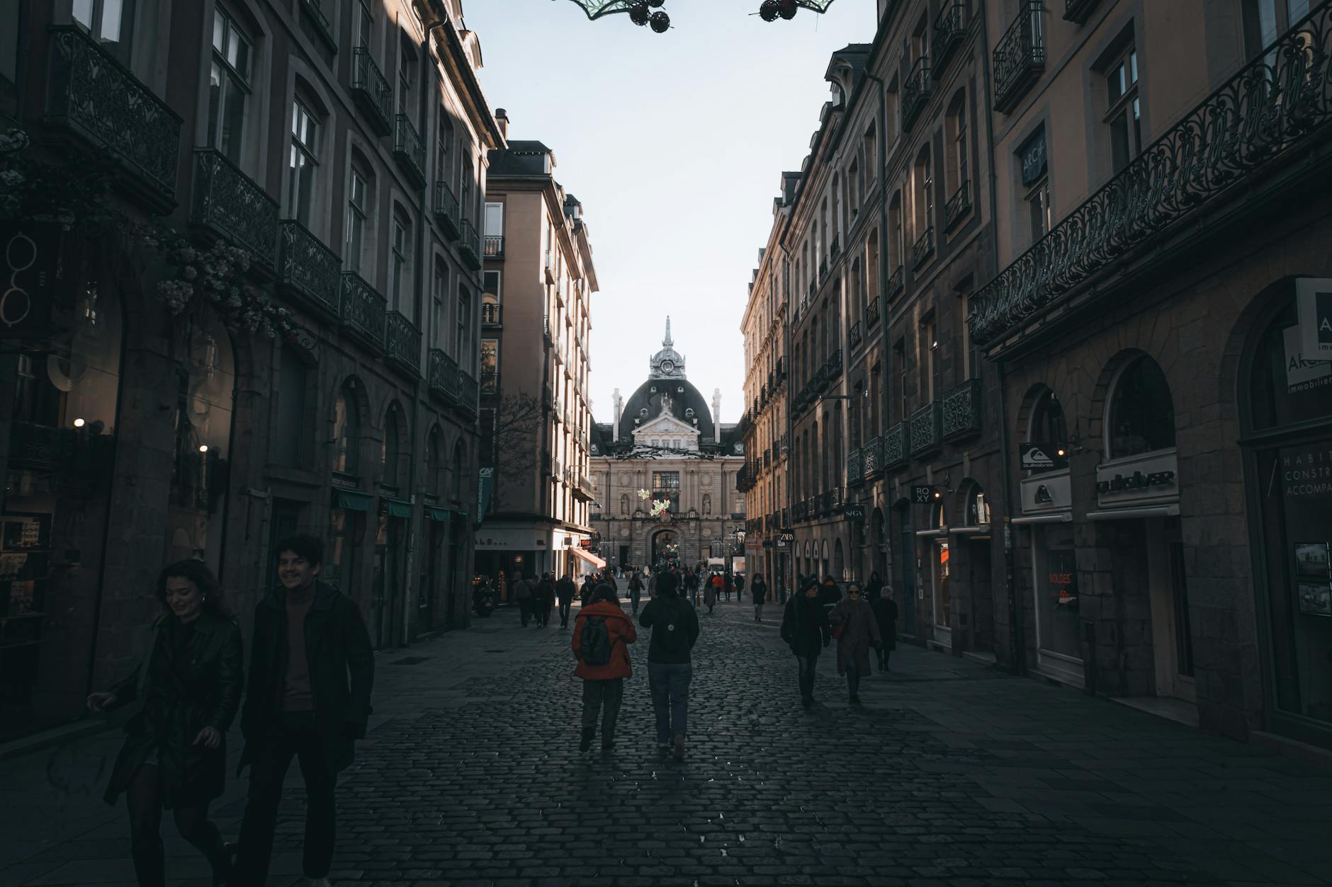 Historyczna ulica w Gnieźnie z eleganckimi kamienicami i spacerowiczami