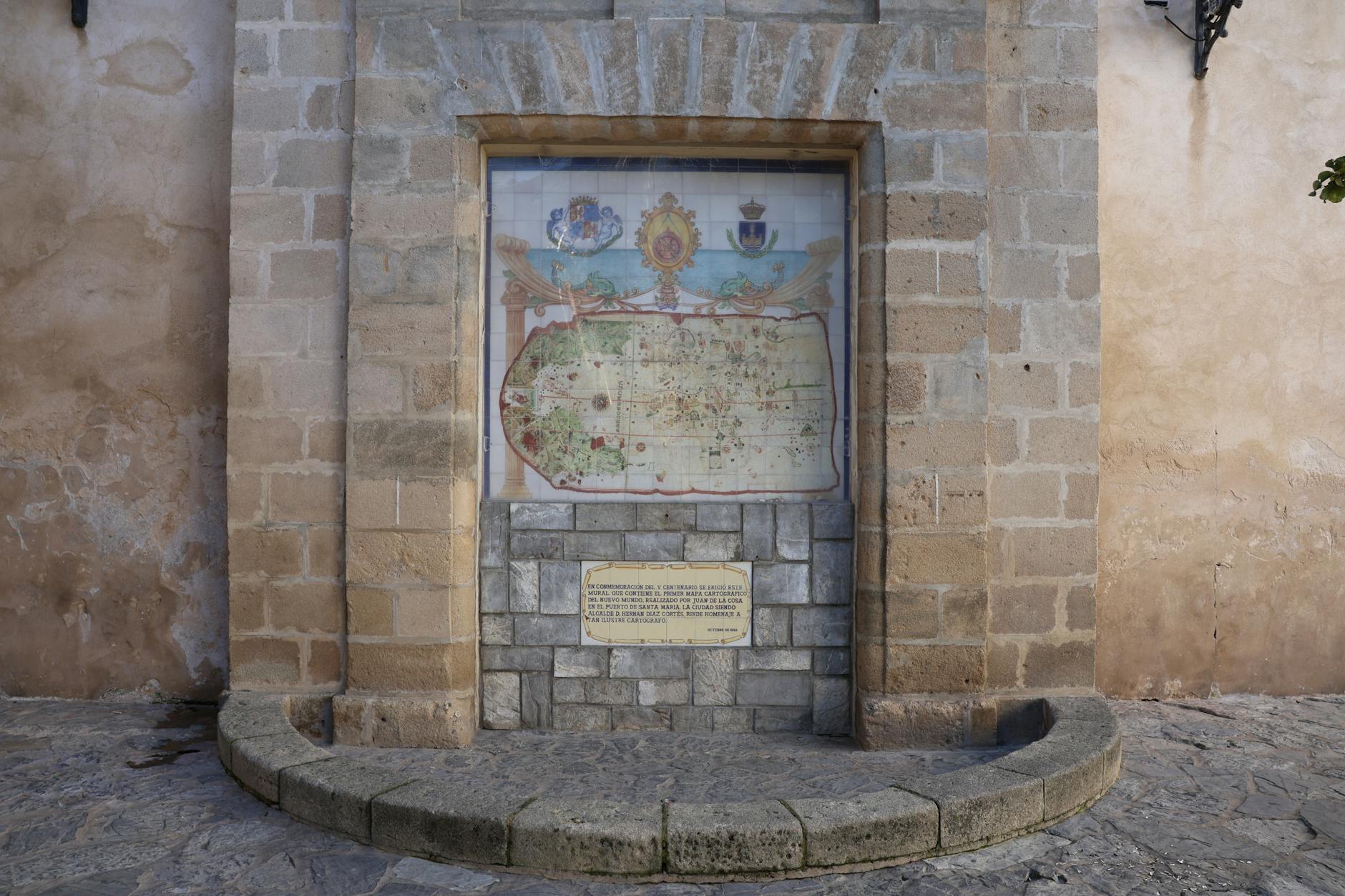 Kamienna tablica z mapą pamiątkową na ścianie budynku