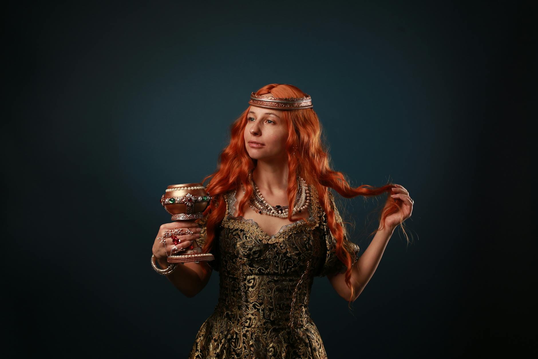 Rudowłosa kobieta w średniowiecznym stroju trzymająca kielich