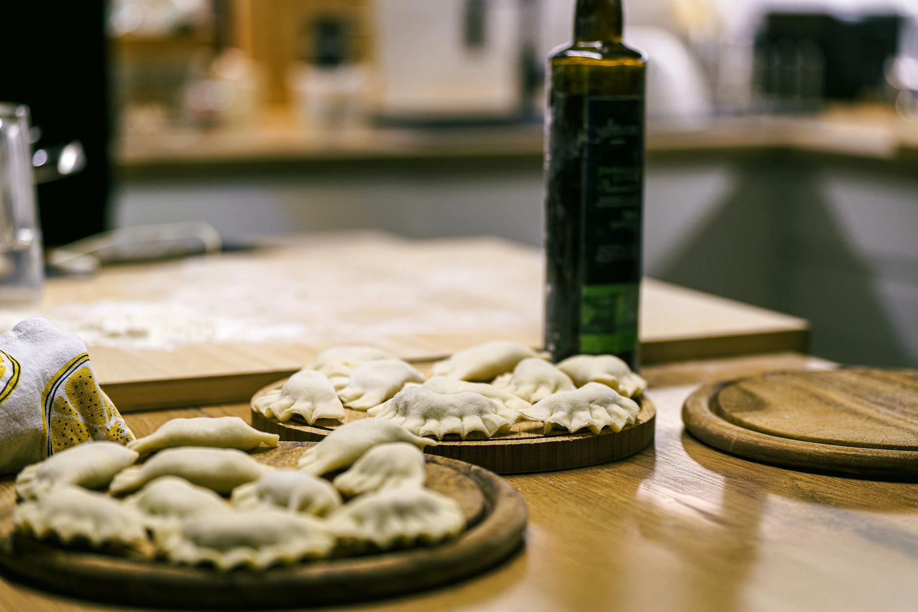 Domowe pierogi ułożone na drewnianych deskach w przytulnej kuchni