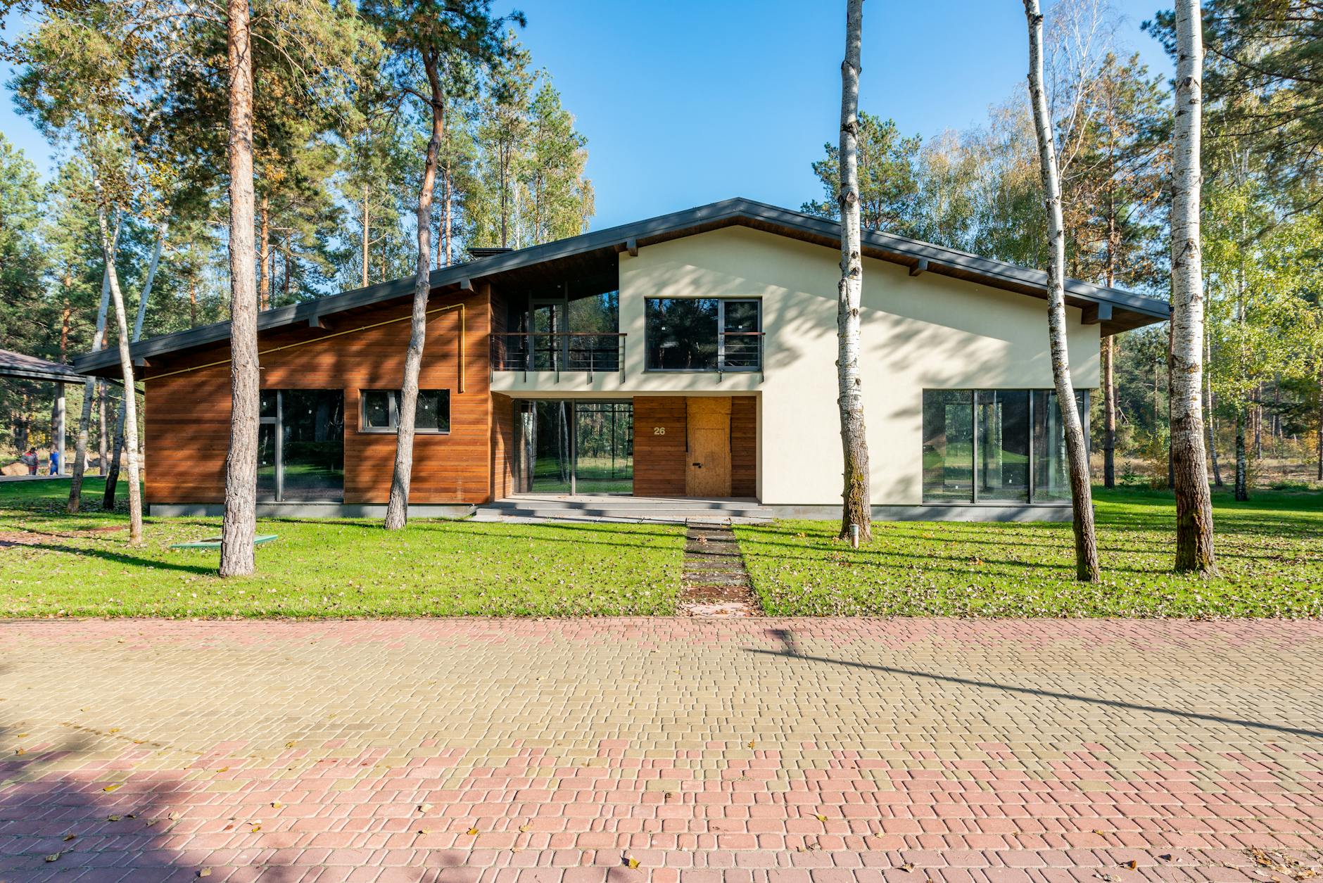 Nowoczesny dom z drewna otoczony bujną zielenią i drzewami