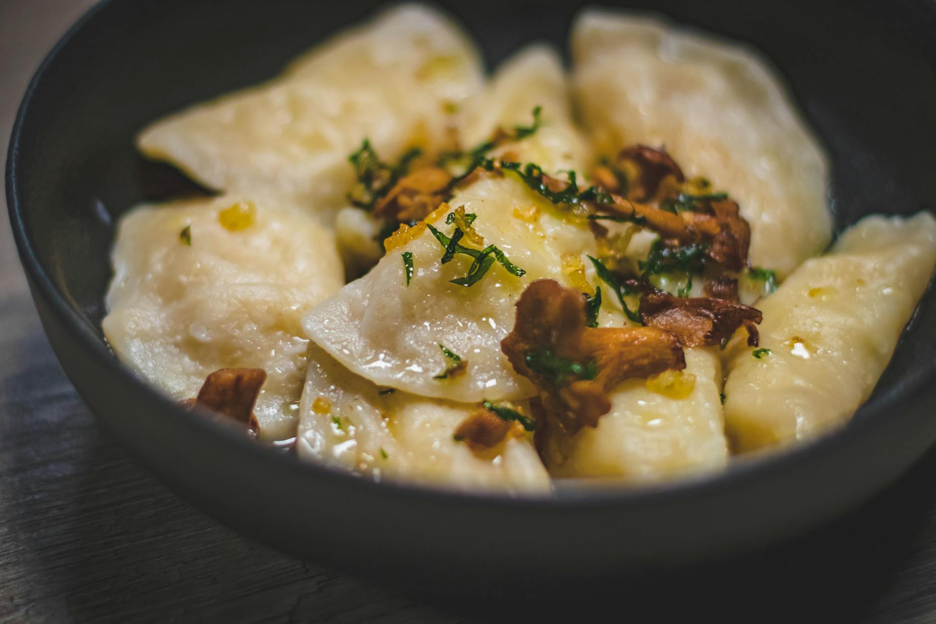 Pierogi z kurkami i ziołami na talerzu w restauracji w Gnieźnie