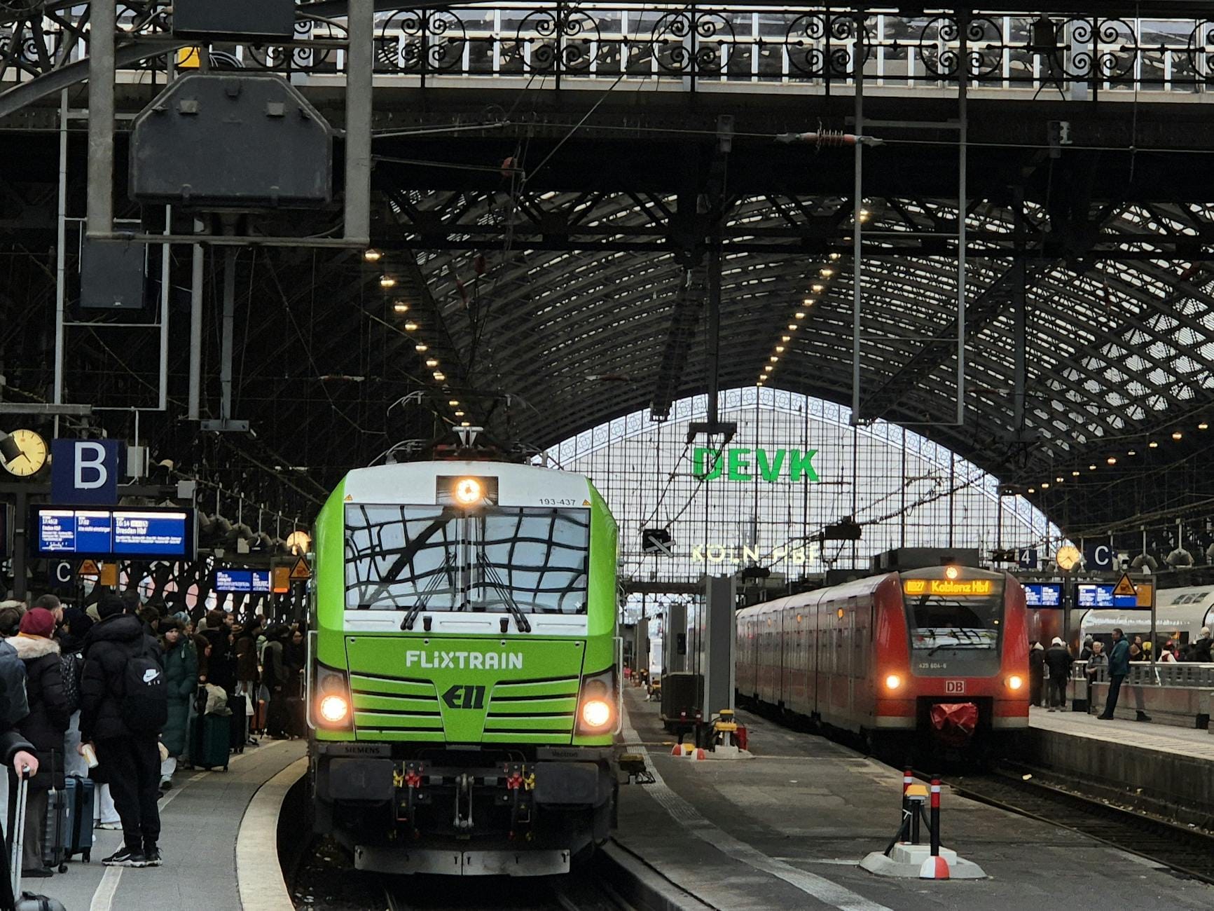 Pociąg Flixtrain i pasażerowie na peronie dużego dworca kolejowego