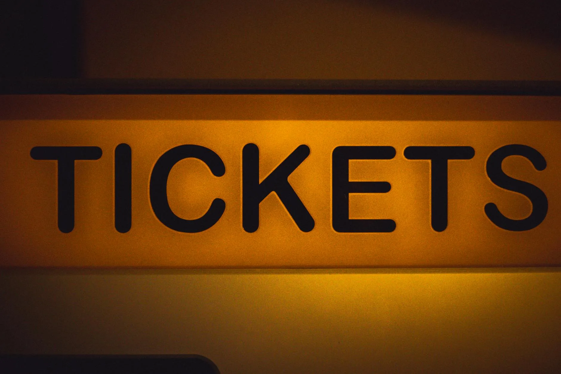Podświetlony żółty szyld ticket na ciemnym tle