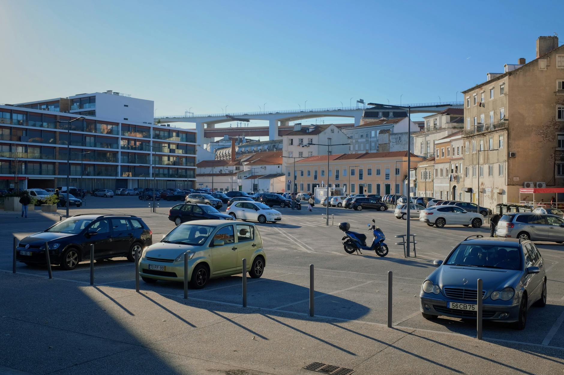 Słoneczny parking z zaparkowanymi samochodami przy miejskich budynkach