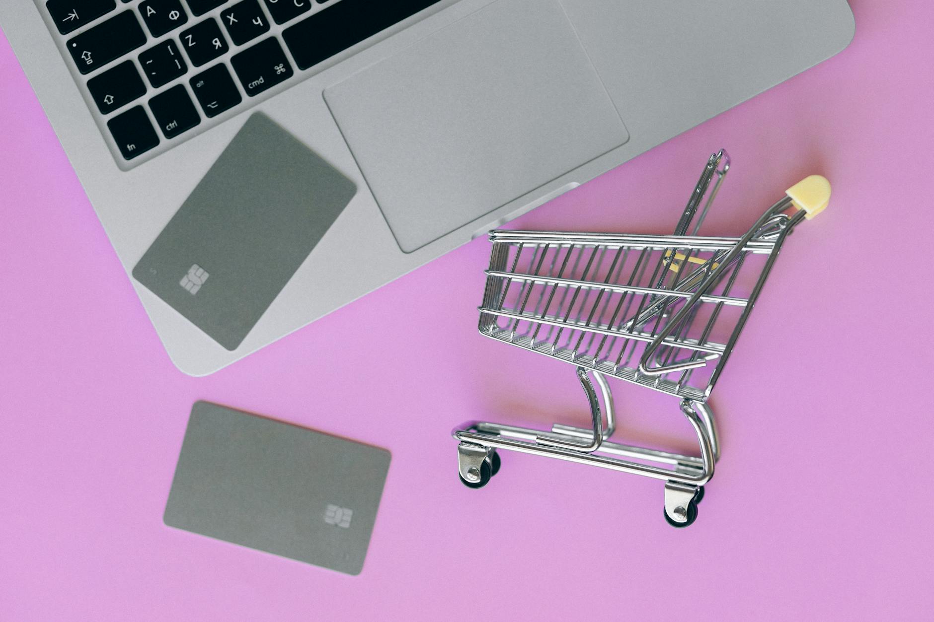 Zakup biletów online na wydarzenia laptop, karta płatnicza i mini wózek