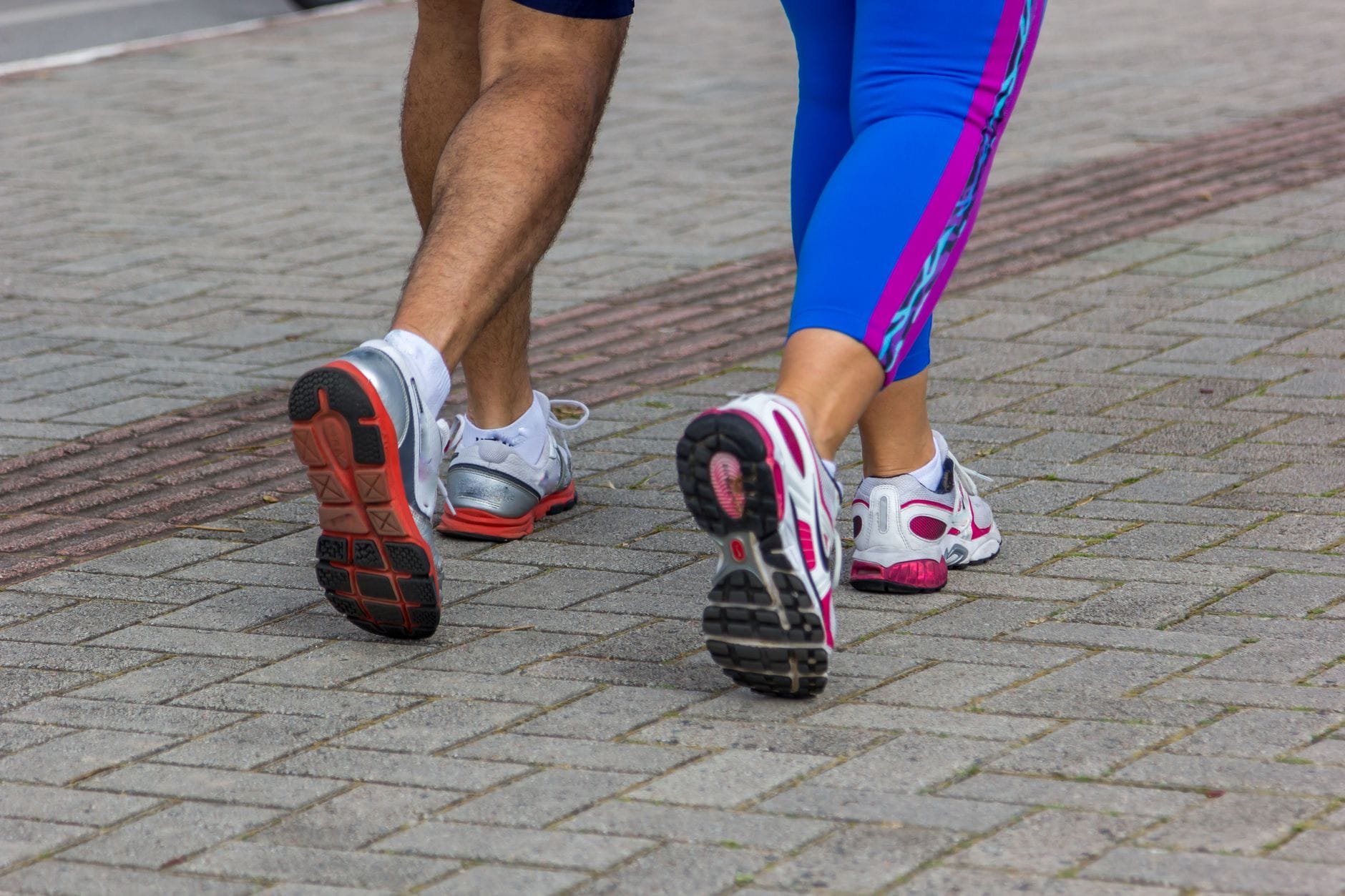 Biegacze w sportowych butach na ulicy w centrum miasta Biegacze w sportowych butach na ulicy w centrum miasta