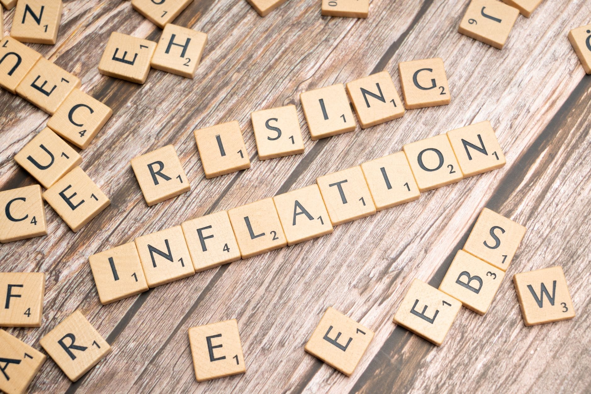 Drewniane kostki z napisem rising inflation nawiązujące do wzrostu cen