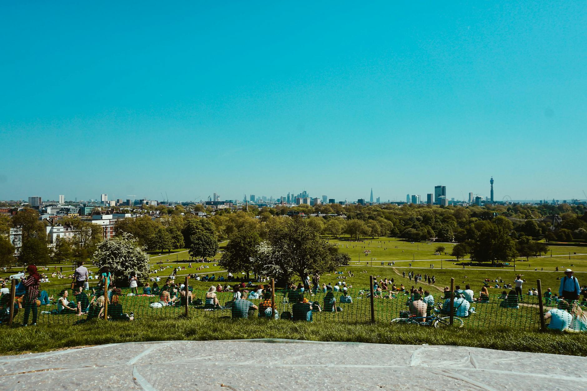 Ludzie odpoczywający na wzgórzu z panoramą nowoczesnego miasta w tle