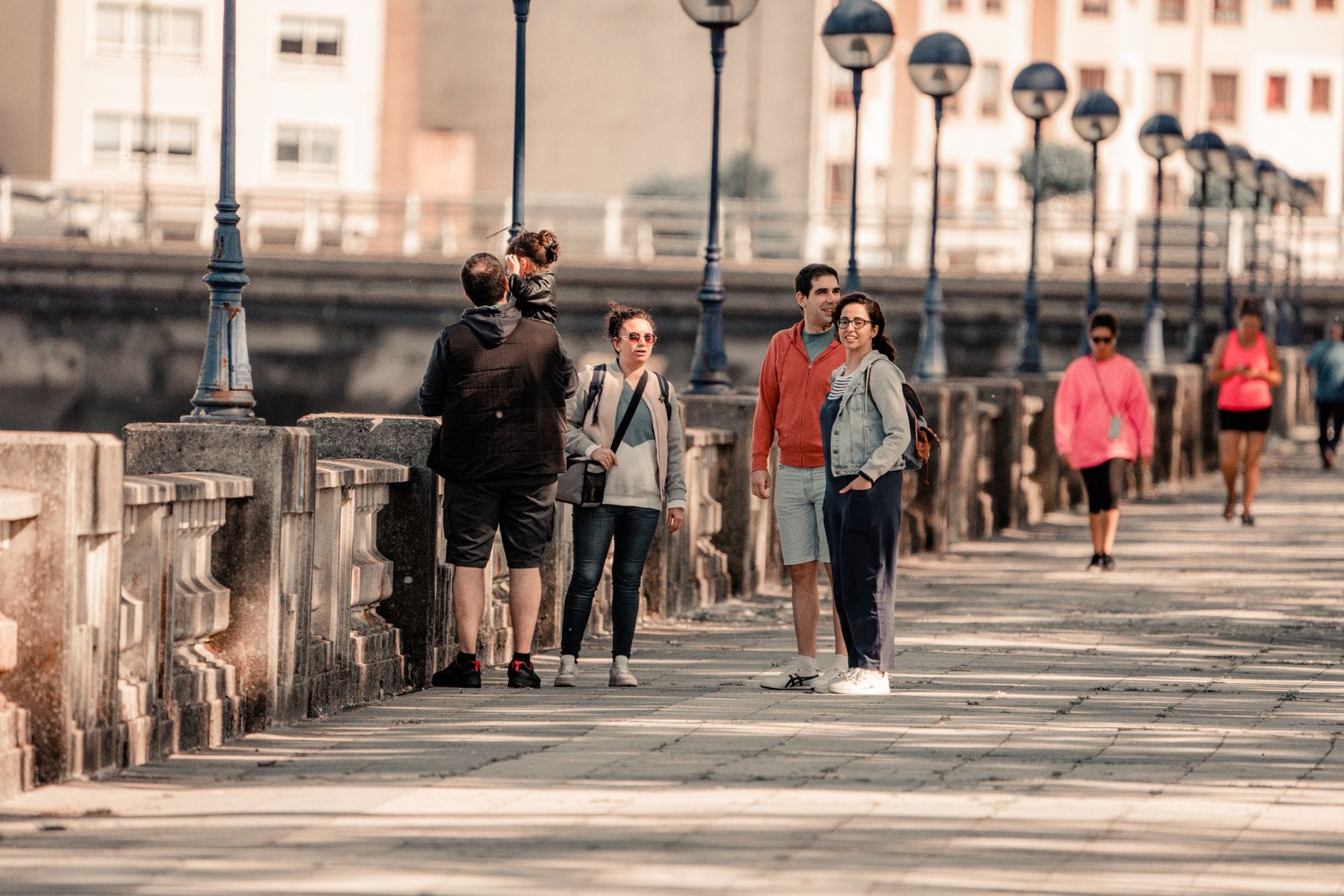 Rodziny spacerują słoneczną promenadą podczas miejskiej wycieczki