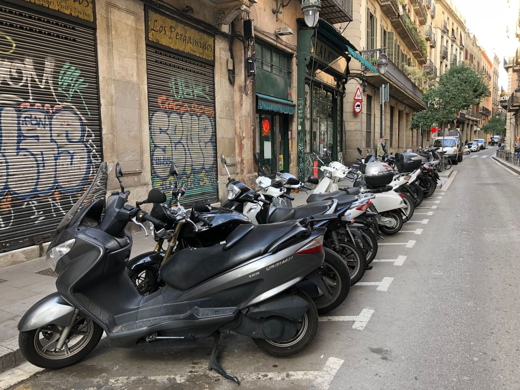 Zaparkowane motocykle przy ulicy z kolorowymi graffitti